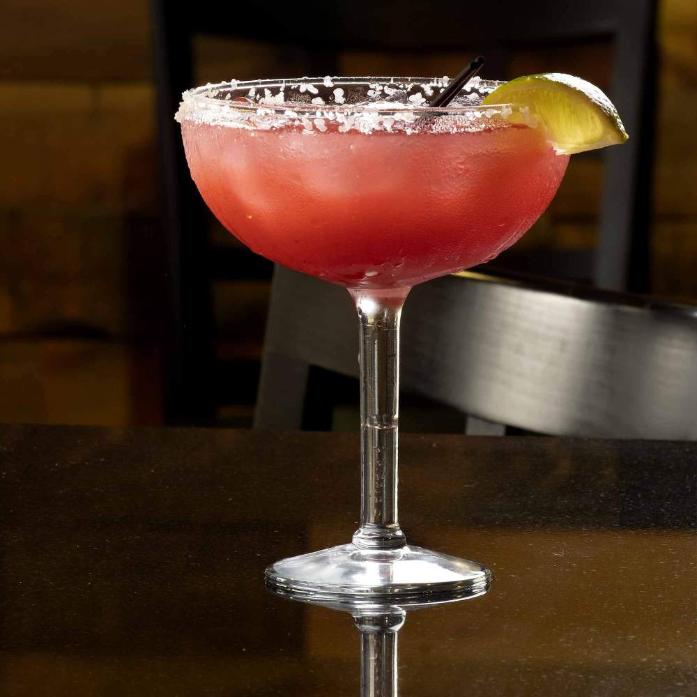 a glass cocktail with a lime slice on the rim